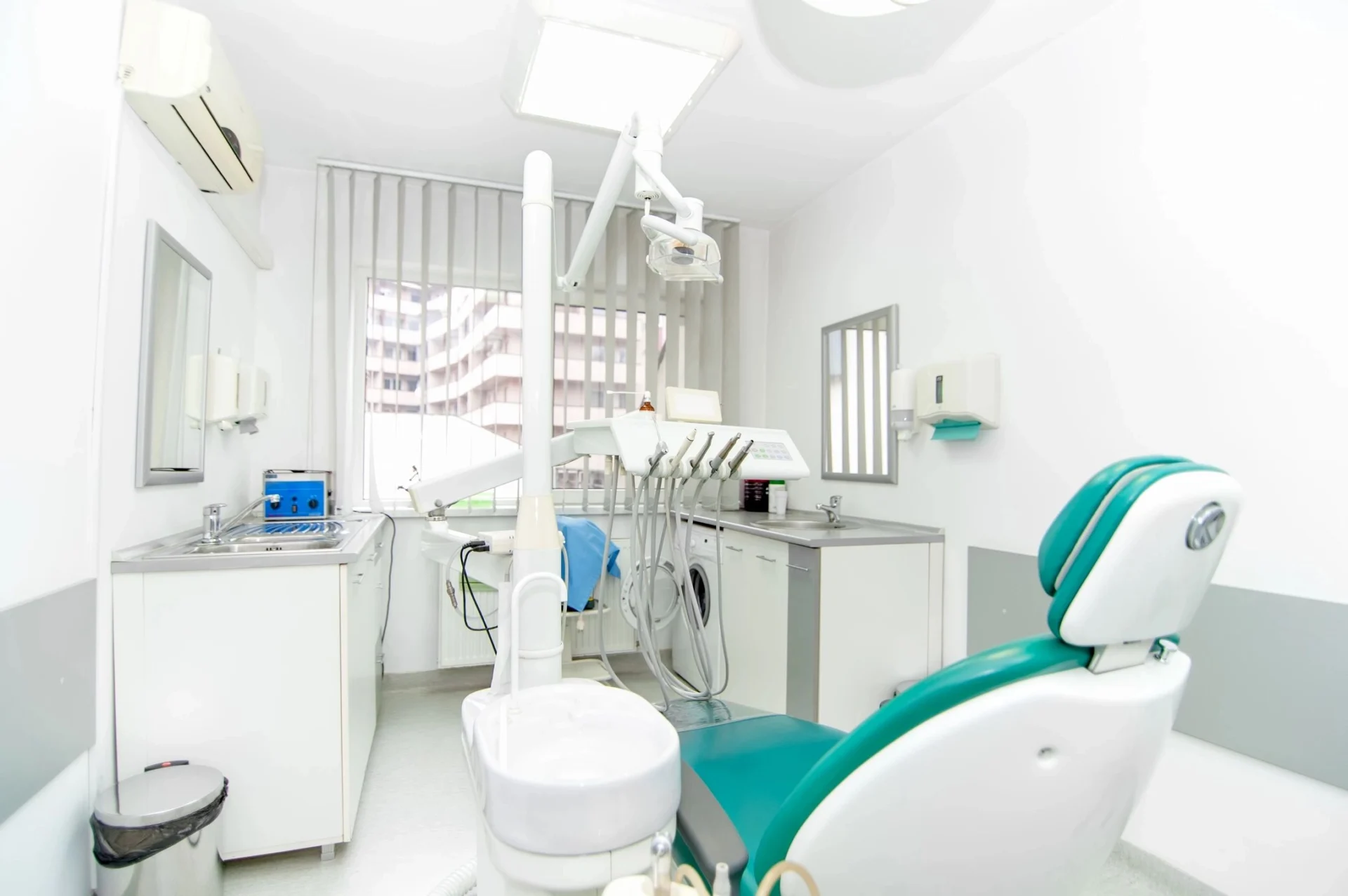 A dentist 's office with a chair and sink.