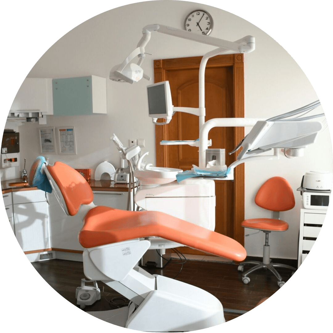 A dentist 's office with orange chairs and white walls.